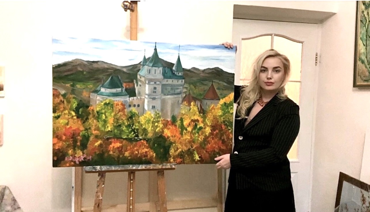 Marina Stognieva with the painting Slovak Castle in her studio, Kyiv, 2022